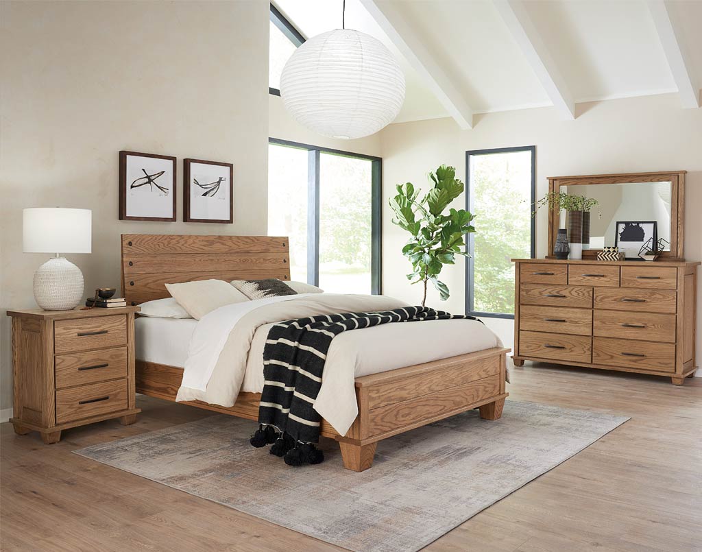 Wooden bedroom furniture set with bed, nightstands, and dresser in a bright room.