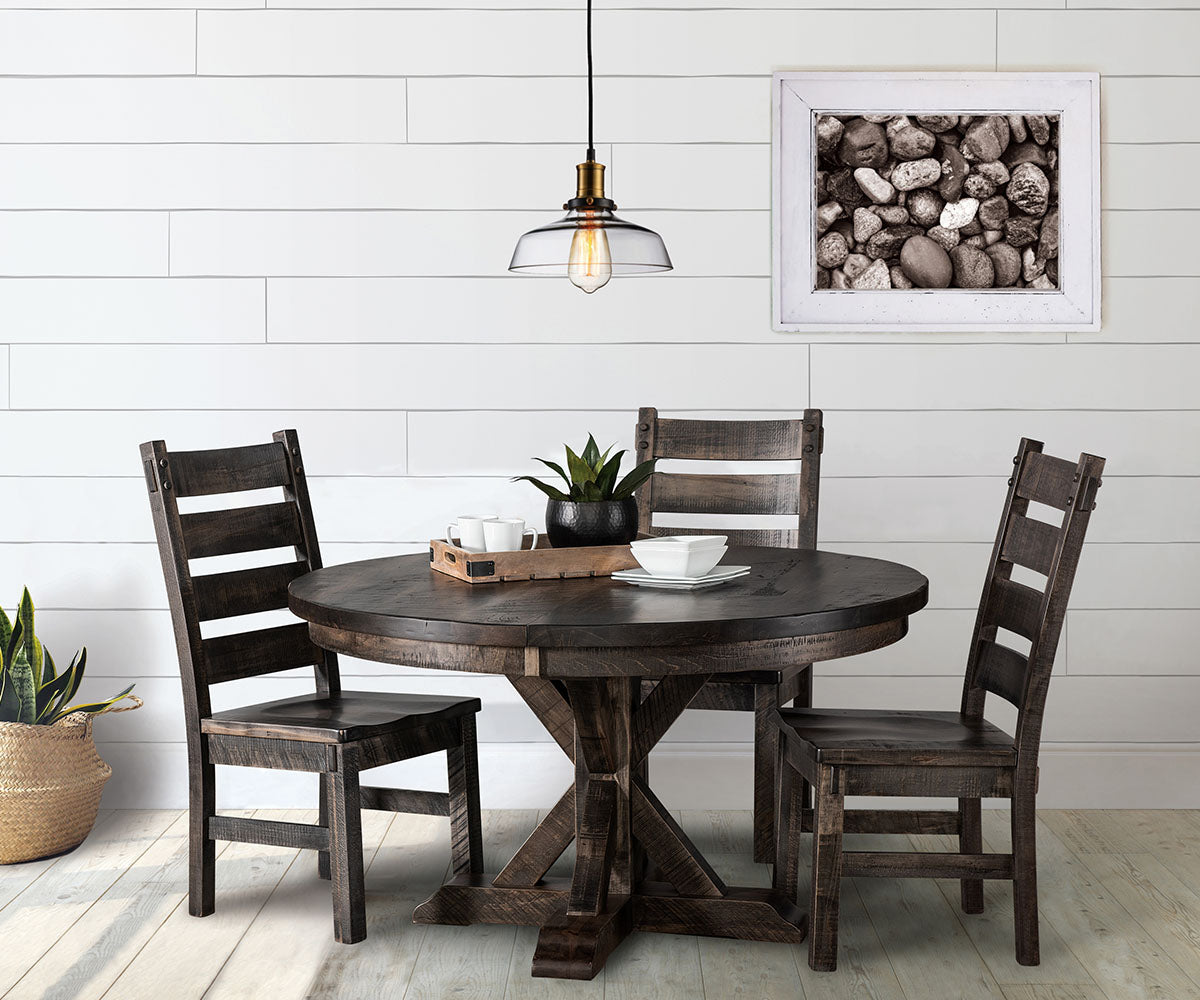 Dining room with wooden table and chairs against a white paneled wall.