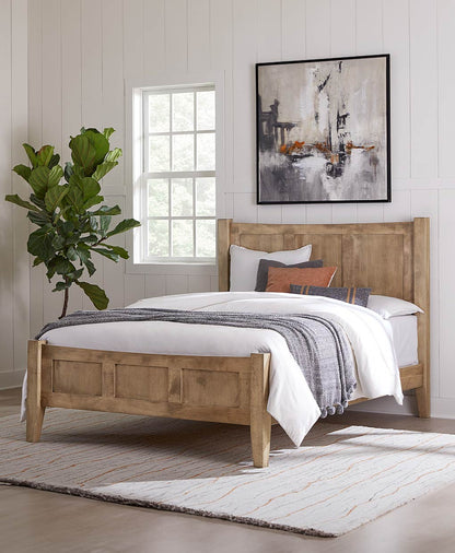 Wooden bed with white bedding and colorful pillows in a room with a plant and abstract painting.