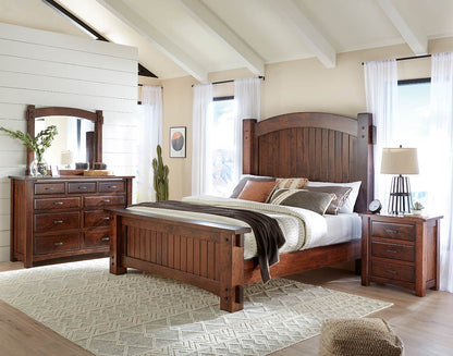 Wooden bedroom set with bed, dresser, and nightstands in a room with large windows.