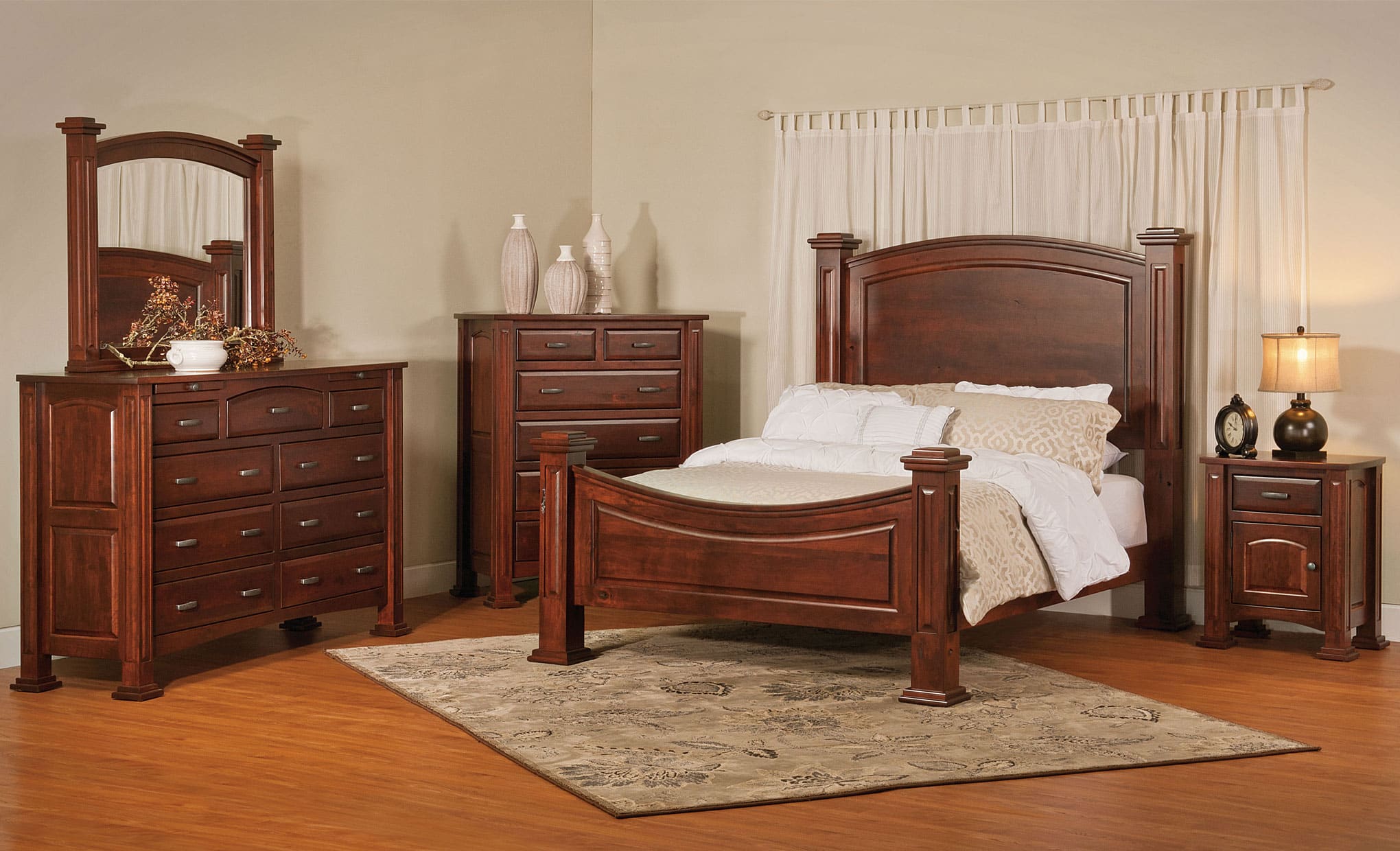Wooden bedroom furniture set including bed, dresser, and nightstands in a room.