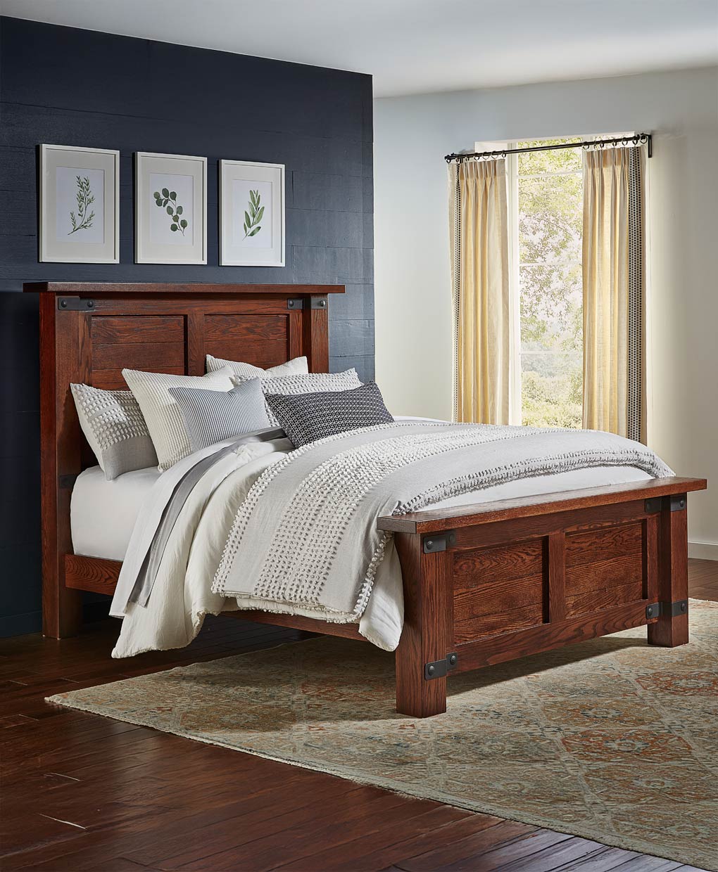 Wooden bed in a bedroom with a dark wall and window with curtains.
