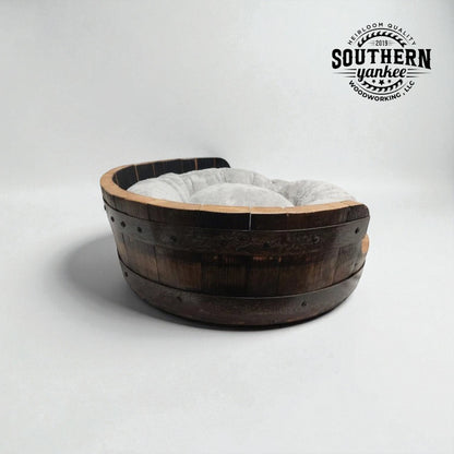 Wooden barrel-shaped pet bed with a fluffy cushion on a white background, branded with 'Southern Yankee'.